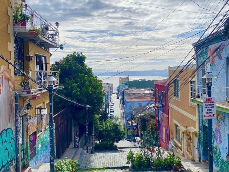 Calle colorida de Valparaíso que baja hacia la bahía, Chile